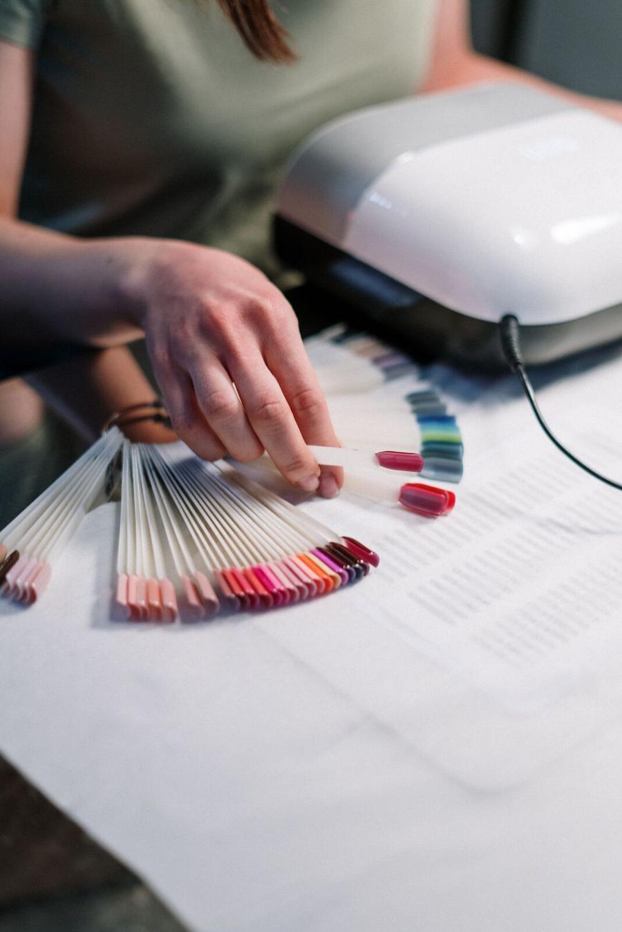 A fan of colour swatches spread across the desk beside a client’s hands
