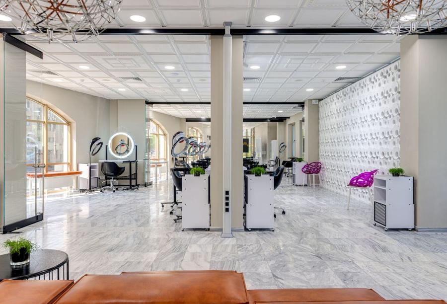 The salon floor, with stations and lit mirrors down the wall